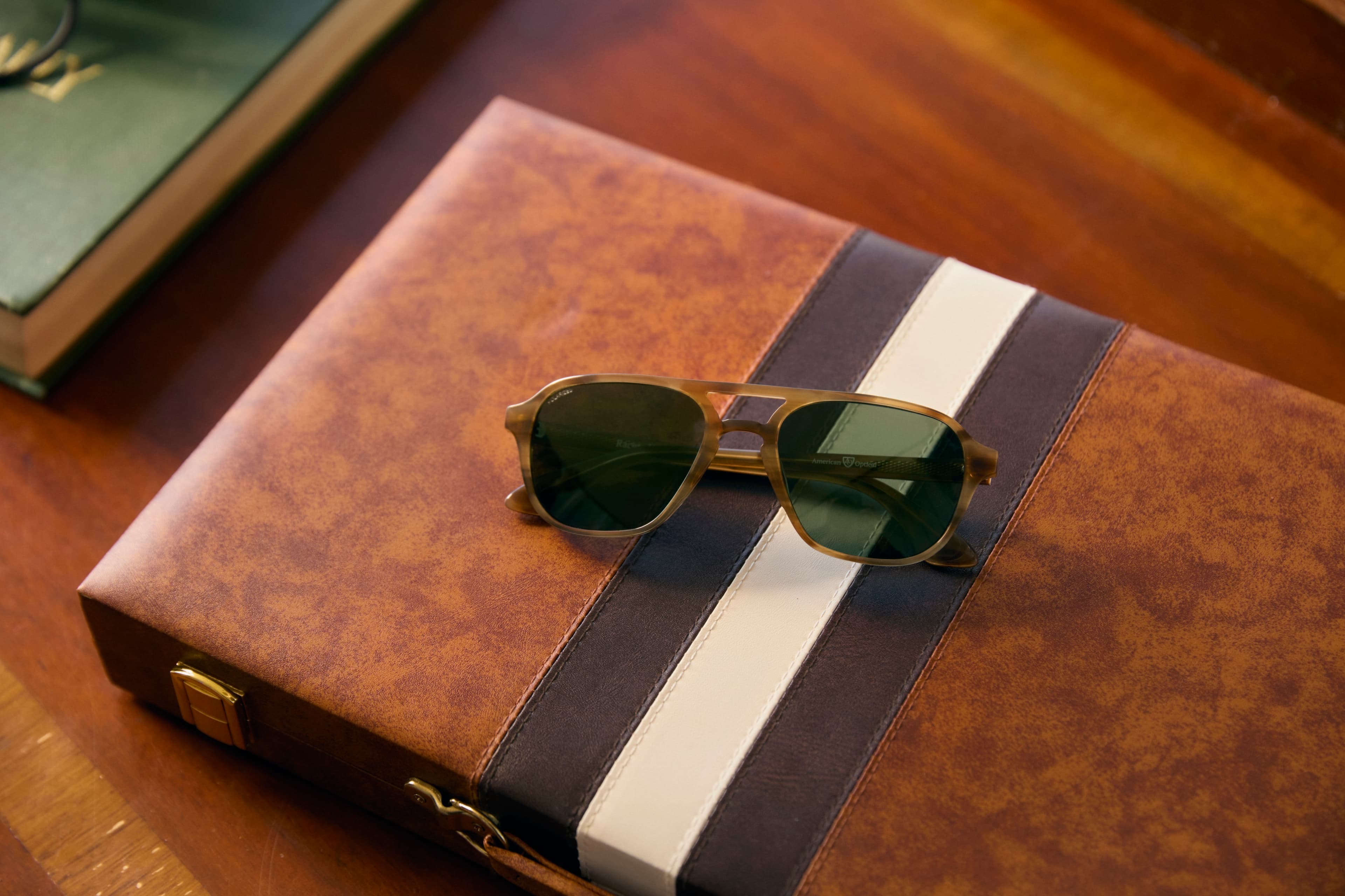 Racer sunglasses from AO Eyewear in Honey on top of a leatherbound journal.